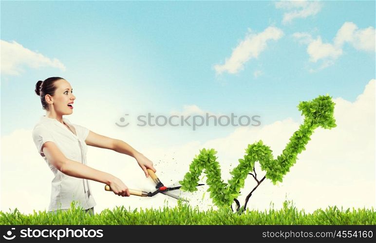 Income concept. Young attractive businesswoman cutting lawn in shape of graph