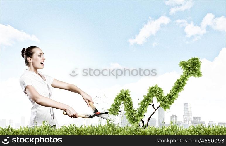 Income concept. Young attractive businesswoman cutting lawn in shape of graph