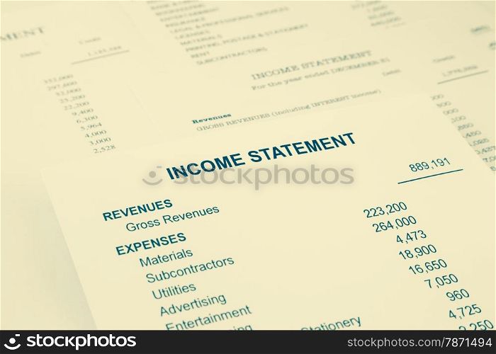 Income statement reports with detail list of revenues and expenses for business accounting concept, sepia tone image