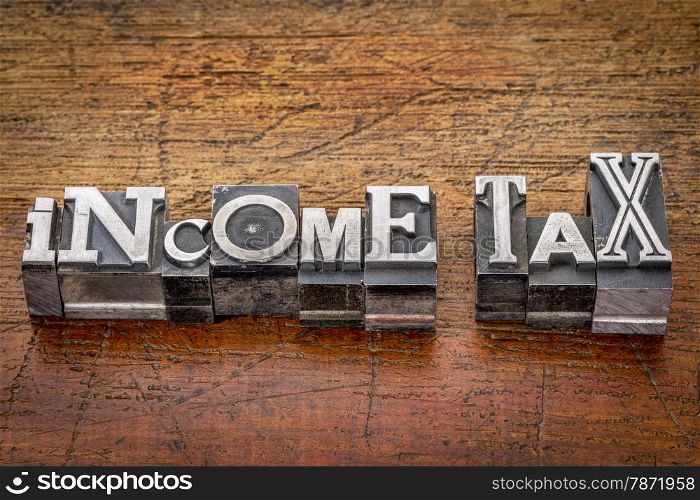 income tax - financial concept - words in mixed vintage metal type printing blocks over grunge wood