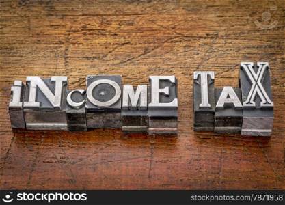 income tax - financial concept - words in mixed vintage metal type printing blocks over grunge wood
