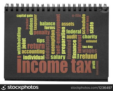 income tax word cloud in a black spiral notebook isolated on white, business, taxes and finance concept