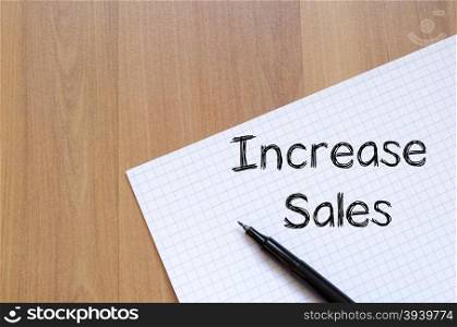 Increase sales text concept write on notebook with pen