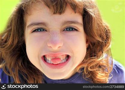 indented little girl sticking tongue between teeth smiling portrait