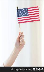 independence day, celebration, patriotism and holidays concept - close up of woman holding american flag in hand at 4th july party
