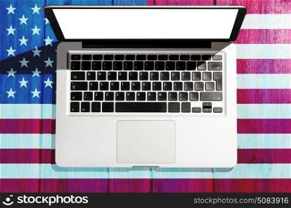 Independence Day laptop. Independence Day and Fourth of July device. Modern laptop computer on blue table with USA flag, view from above