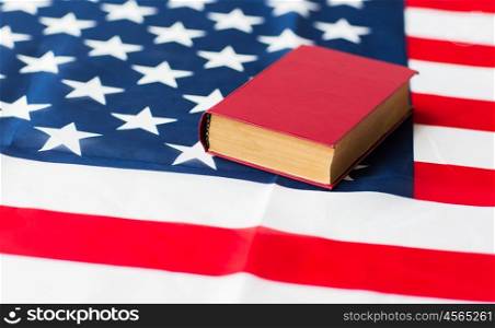 independence day, patriotism, civil rights, cultural values and nationalism concept - close up of american flag and constitution book or bible