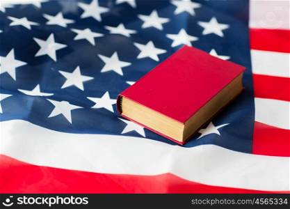 independence day, patriotism, civil rights, cultural values and nationalism concept - close up of american flag and constitution book or bible