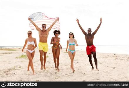 independence day, summer holidays and people concept - group of happy friends with american flag on beach. happy friends with american flag on summer beach