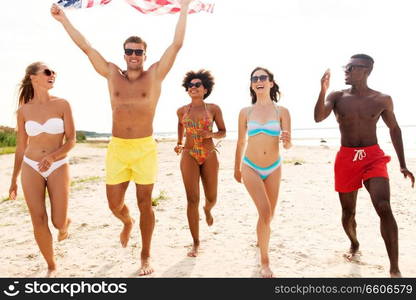 independence day, summer holidays and people concept - group of happy friends with american flag on beach. happy friends with american flag on summer beach