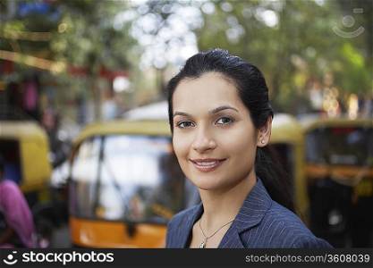 India, business woman standing on street, portrait