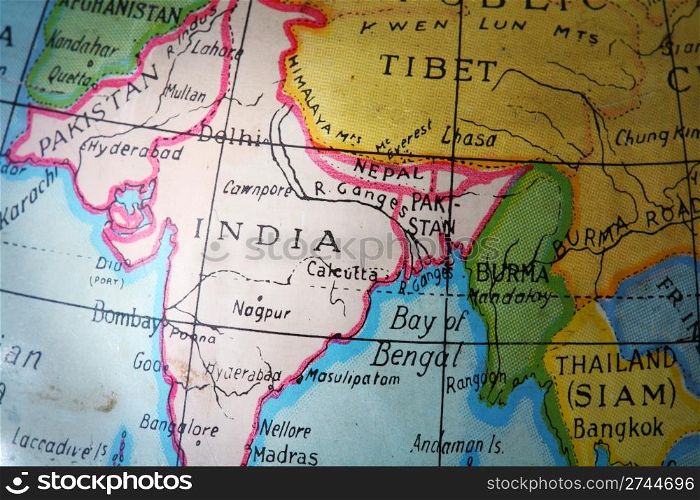 India on a worn, old and dirty metallic toy globe