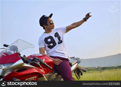 Indian Boy with Motor Bike and mountain background. Pune, Maharashtra.