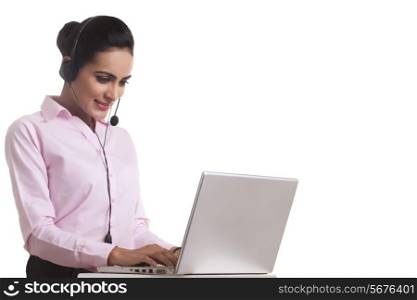 Indian businesswoman using headset and laptop against white background