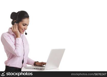 Indian businesswoman using headset and laptop over white background