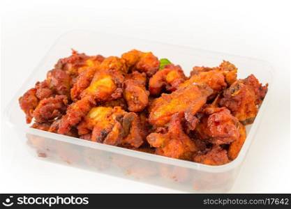 Indian Chicken 65 nuggets in a takeaway plastic pot, a favourite light spicy snack in the subcontinent