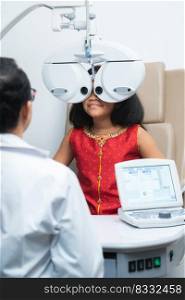 Indian child girl doing subjective refraction with phoropter digital modern machine and ophthalmologist or optometrist for eyes test at hospital or optometry clinic