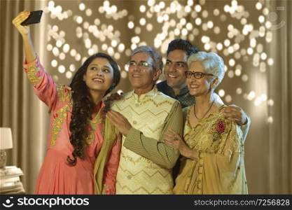 Indian family taking selfie or self photograph at home on diwali festival