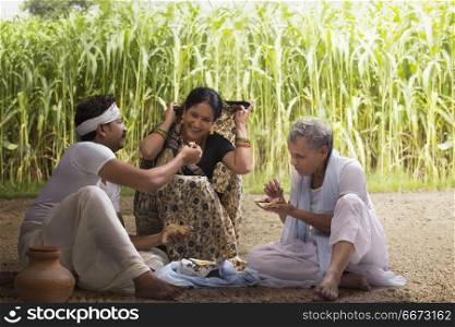 Indian farmer family having lunch in field