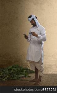 Indian farmer holding mobile phone and credit card