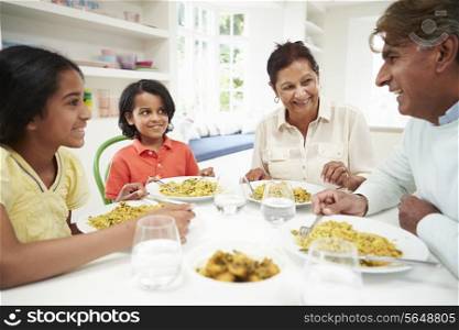 Indian Grandparents And Grandchildren Eating Meal At Home