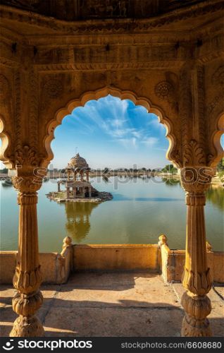 Indian landmark Gadi Sagar - artificial lake view through arch. Jaisalmer, Rajasthan, India. Indian landmark Gadi Sagar in Rajasthan