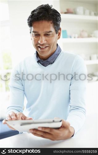 Indian Man Using Digital Tablet At Home