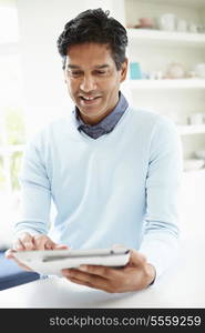 Indian Man Using Digital Tablet At Home