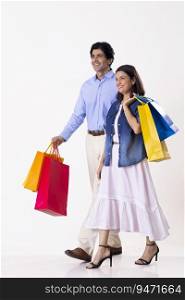 Indian middle age couple walking together with shopping bags