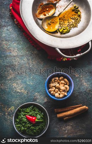 Indian or oriental cuisine and food background with colorful spices, nuts and green paste, top view