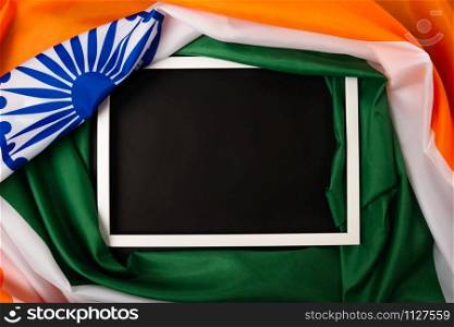 Indian republic day, flat lay top view, Indian flag and photo frame on black background with copy space for your text