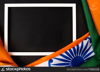 Indian republic day, flat lay top view, Indian flag and photo frame on black background with copy space for your text