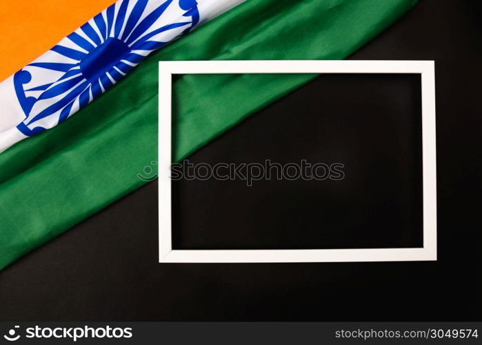 Indian republic day, flat lay top view, Indian flag and photo frame on black background with copy space for your text