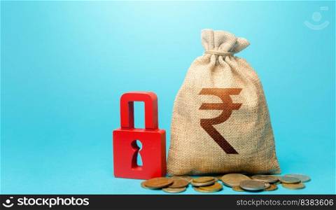 Indian rupee money bag and red padlock. Blocking bank accounts and seizing assets. Freezing of pension savings. Cash flow monitoring. Tight government control over the financial system.