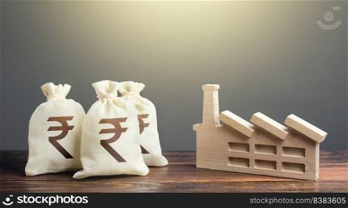 Indian rupee money bags and industrial factory plant. Privatization and purchase of industrial complexes. Investment in modernization, reduction harm to environment. Economic support.