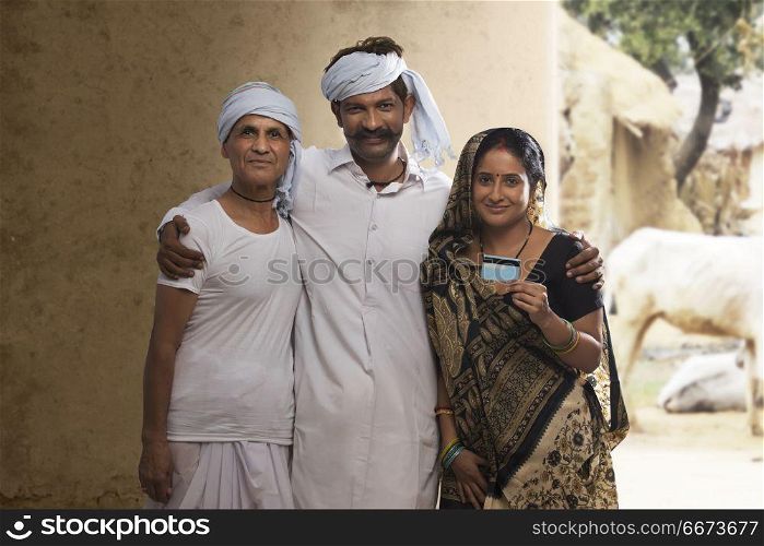 Indian rural farmer family holding credit card