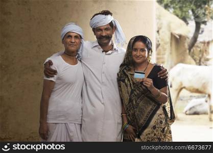 Indian rural farmer family holding credit card