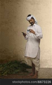Indian rural farmer holding mobile phone and credit card