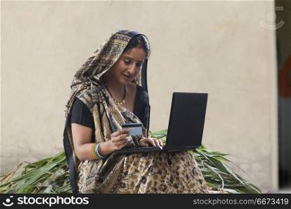 Indian rural woman using laptop and credit card