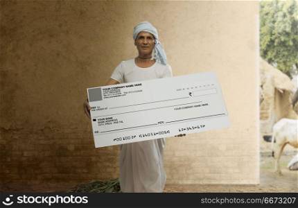 Indian senior farmer showing a bank cheque