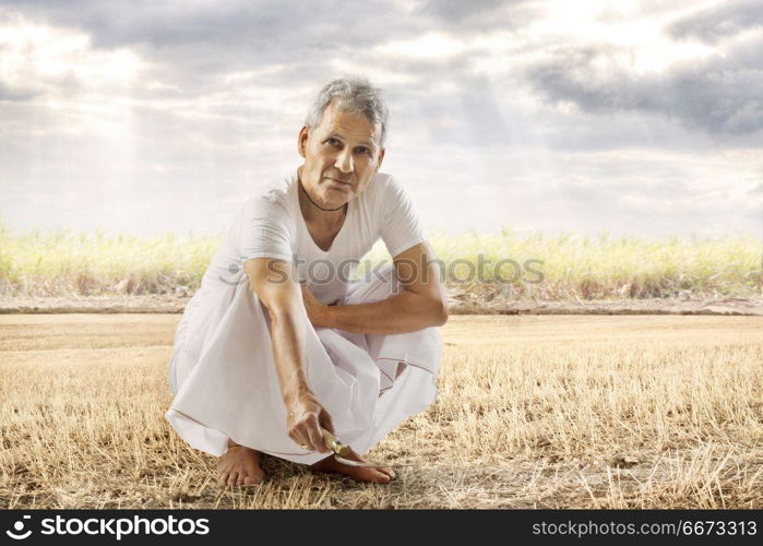 Indian senior farmer working in his field at farm
