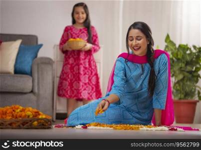 Indian woman decorating house with flowers and her daughter standing behind 