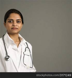 Indian woman doctor head and shoulder portrait on gray background.