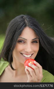 Indian woman eating a tomato