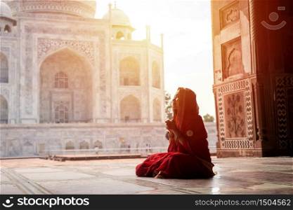 Indian woman in red saree/sari in the Taj Mahal, Agra, Uttar Pradesh, India
