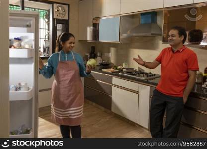 Indian woman talking to her husband in the kitchen