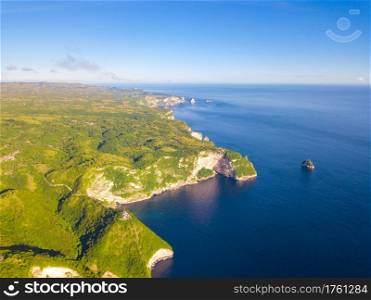 Indonesia. Rocky tropical ocean shore in calm and sunny weather. Castle on the top of the cliff. Aerial view. Tropical Shore and Castle on the Cliff. Aerial View
