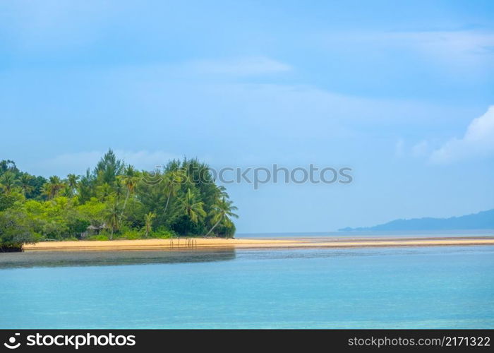 Indonesian island in the Raja Ampat archipelago. Sandy spit on the coast of a tropical island. The lone hut is hidden behind the trees. Not a single person in sight. Hut on the Shore of a Tropical Island With a Sand Spit
