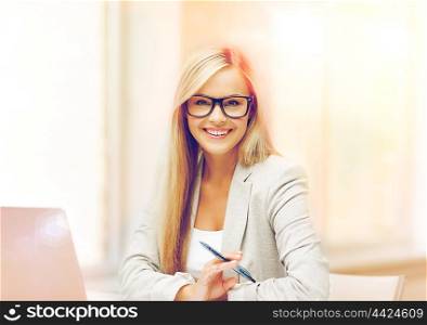indoor picture of smiling woman with laptop and pen. businesswoman with pen