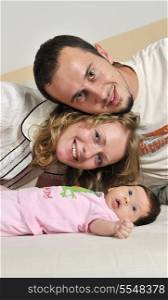 indoor portrait with happy young famil and cute little babby